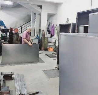 Steel work factory: operator beside finished steel panels