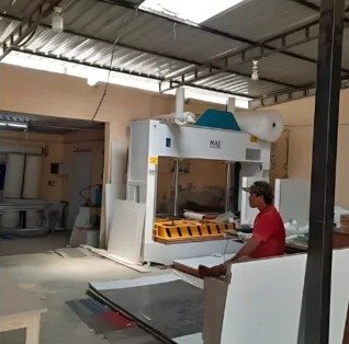 Wood work factory: panel press machine with an operator
